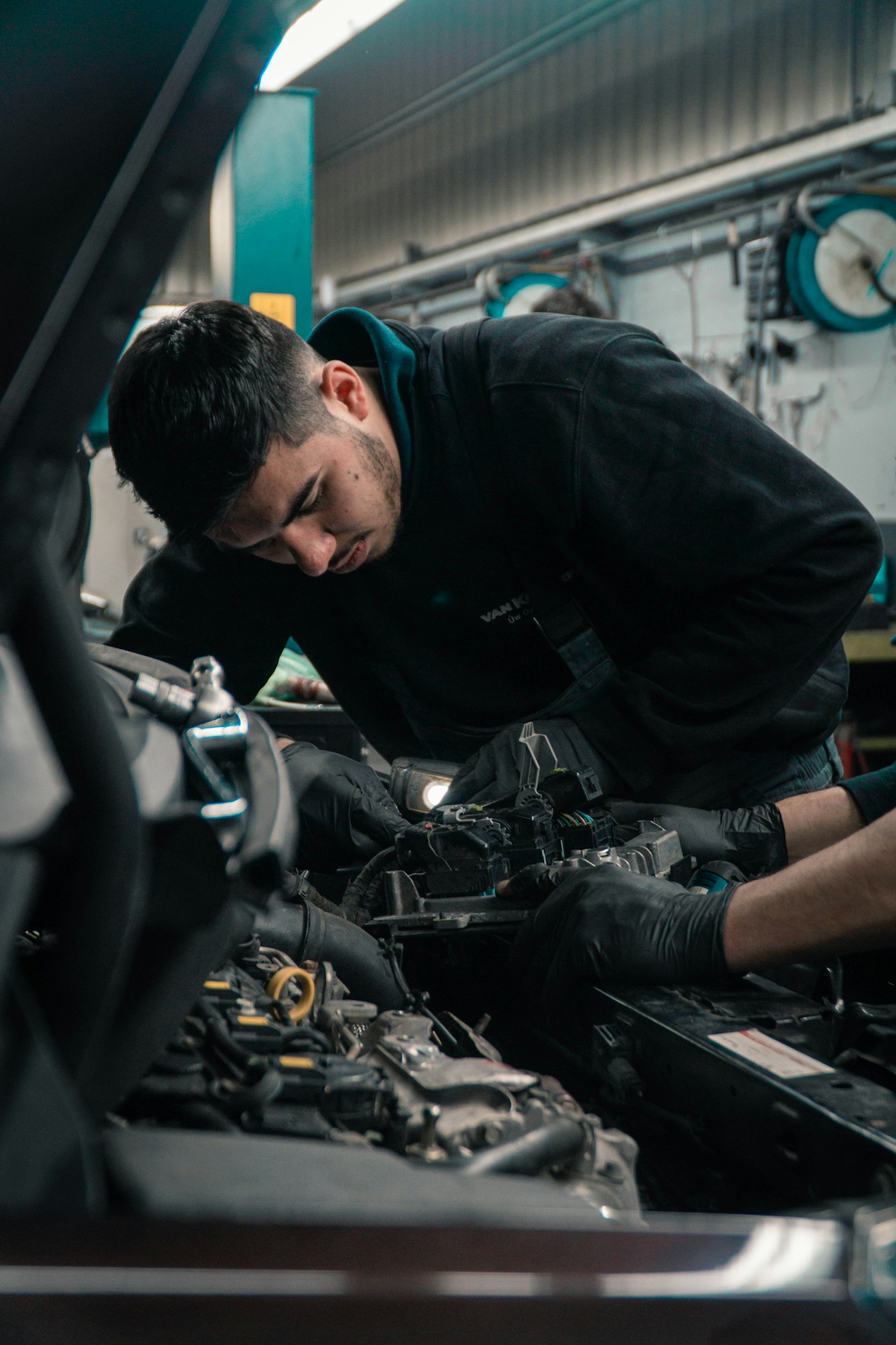 Valvoline Oil Change technician working under the hood in the service bay